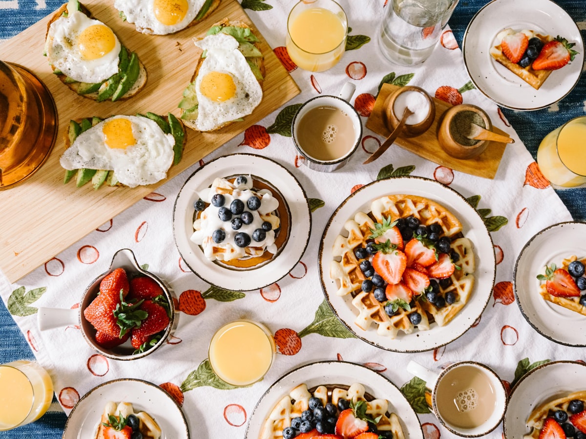 Mesa de brunch con panes, fruta y café