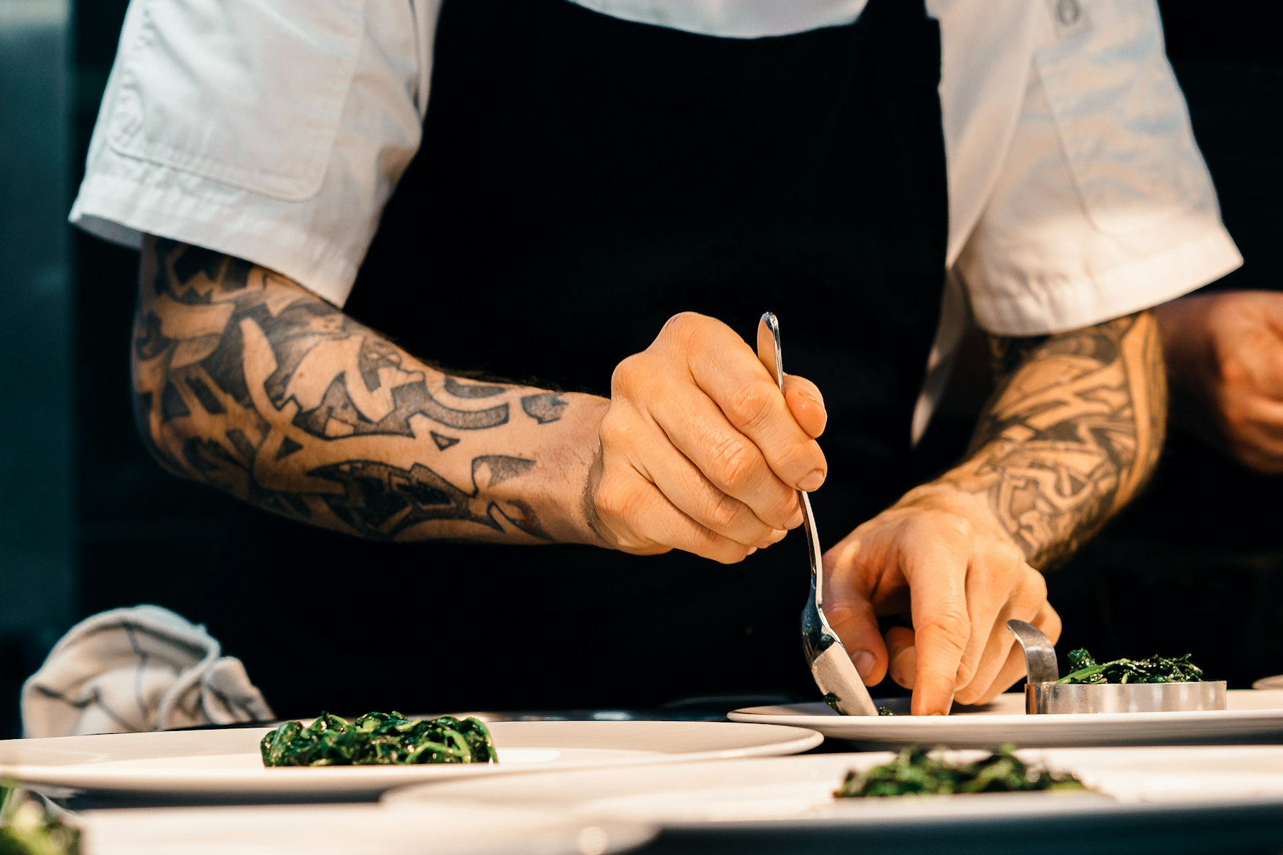 Chef emplatando con precisión un platillo de alta cocina